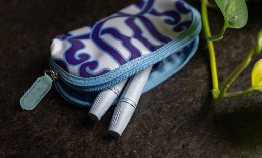 Female compact catheters in makeup bag on countertop