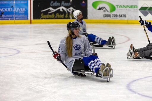 Heidi playing adaptive sled hockey with her team