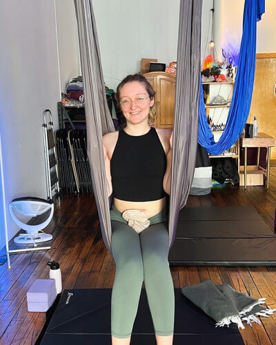Molly doing aerial yoga with her ostomy pouch